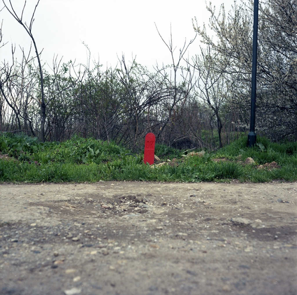 Red color is associated with danger, that is why you eye is immediately drawn do the red object in the image, despite its small size.